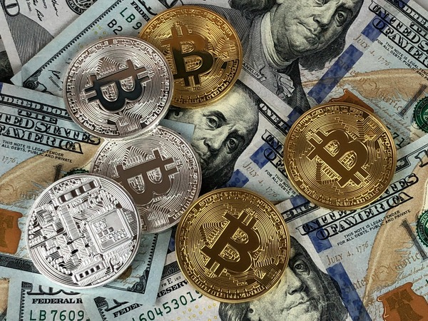 Bitcoin coins placed on top of US dollar banknotes